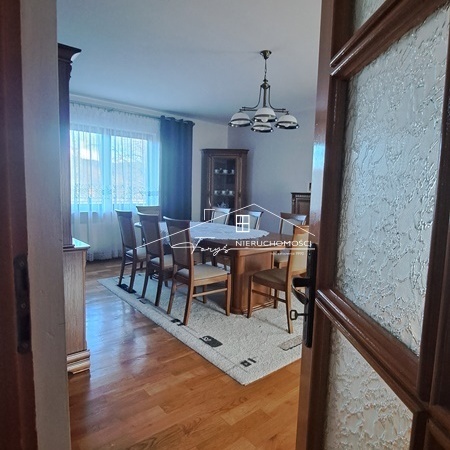 Kup dom z pięknym ogrodem, drzewami i krzewami iglastymi.