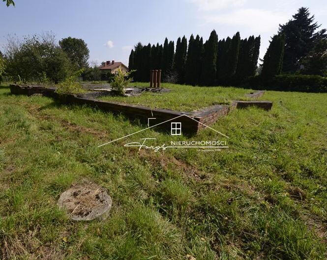 Postaw dom w otoczeniu zieleni, na płaskim, częściowo zadrzewionym terenie.