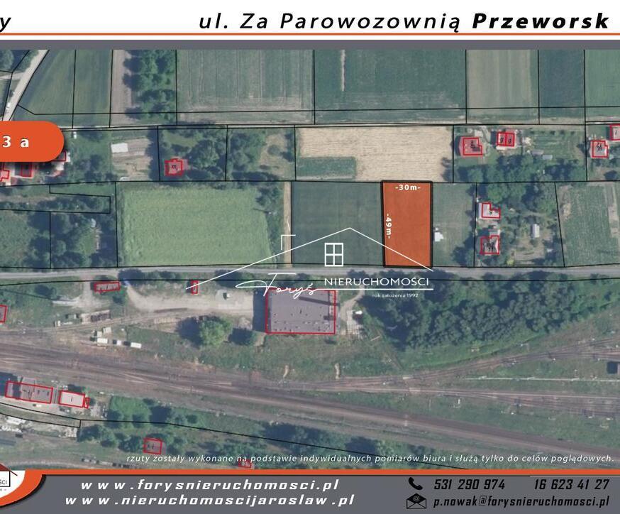 Spokojna okolica, niska zabudowa, w pobliżu pola uprawne i zieleń.