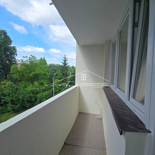 Loggia z widokiem na zadrzewiony ogród idealna na relaks i poranną kawę.