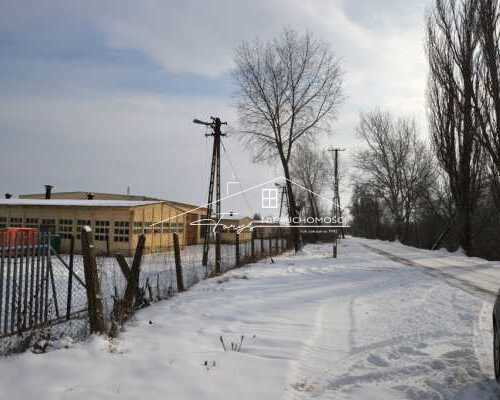 Ogrodzona nieruchomość z utwardzonymi placami i drogami wewnętrznymi.